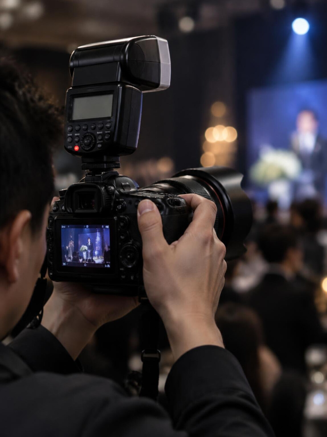 Camera with flash on a photographer shooting an event
